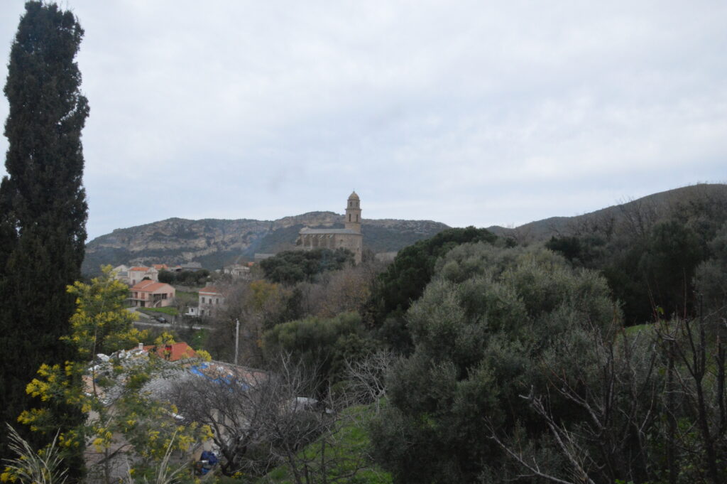 Vue d’un village corse avec église et collines, ambiance de printemps liée aux traditions de Pâques